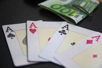 Four aces next to bundles of euro banknotes