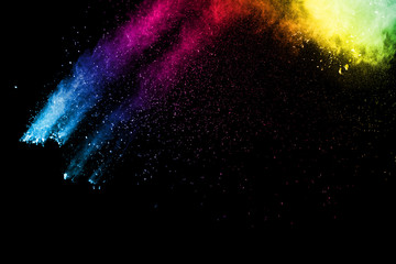 The explosion of colored powder. Beautiful powder fly away. The cloud of glowing color powder on black background