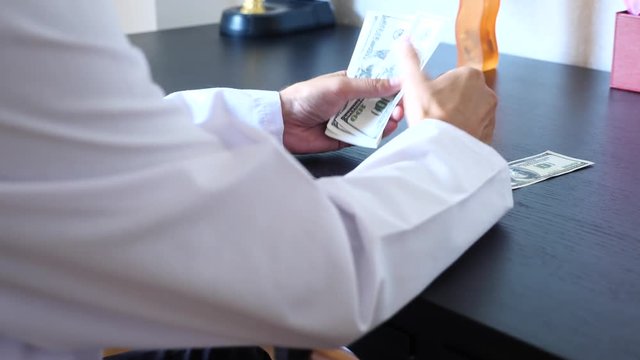 Corruption, bribery and fraud are. a close-up of a doctor taking money. 4k . slow motion