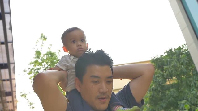 Slow motion of Happy little Asian boy playing with his father outdoor