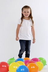 Fototapeta na wymiar Kleines Mädchen geht zwischen Ballons