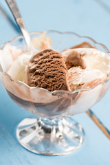 Vanilla and chocolate ice cream in the crystal bowl on the wooden planks