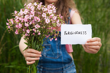 Forgiveness - woman with word and bouquet of pink flowers