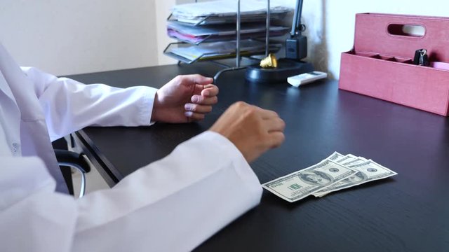 Corruption, bribery and fraud are. a close-up of a doctor taking money. 4k . slow motion