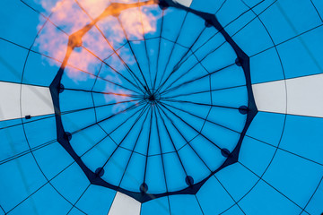 Naklejka premium Close-up of abstract beautiful texture of geometric surface of hot air balloon, blue colors and flame from burner. Background for bright moments of life