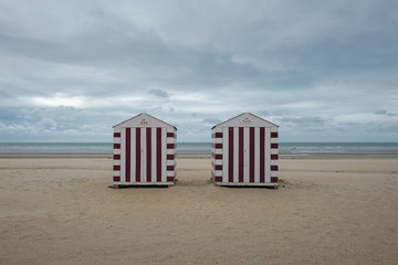 Two colorful beach cabins on a cloudy day