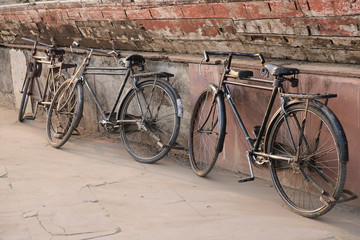 Fototapeta na wymiar Old indian bicycles leaning on the temple wall.