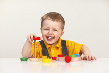 Little boy playing with wooden toys. Isolated