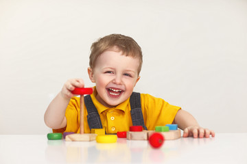Little boy playing with wooden toys. Isolated