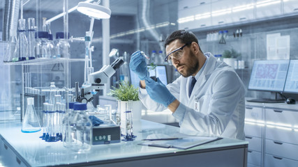 In a Modern Laboratory Research Scientist Conducts Experiments by Synthesising Compounds with use...