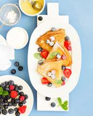 Obraz premium Pancakes with fresh berries and honey.