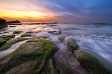 Fototapeta premium Long expose sunset with waves trails at Kudat Sabah Malaysia. Image contain soft focus due to long exposure.