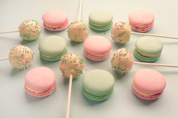 Closeup of sweet macaroons with cake pops or cake crumbs with icing on sticks