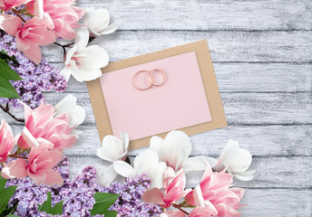 Magnolia, lilacs, bridal rings and paper card for wedding