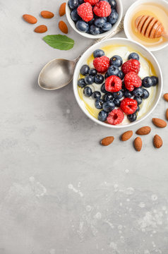 Natural yogurt with fresh berries and honey, healthy breakfast concept, top view, copy space