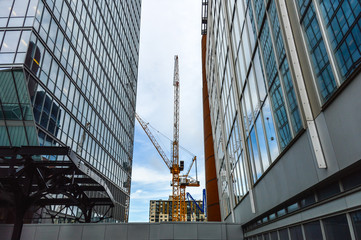 The tall business skyscrapers and the construction crane in the heart of Montreal downtown.