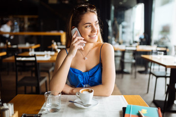 Beautiful woman in cafe using phone