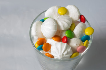 colorful candies and sweets, meringue in a glass on a white background