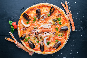 Seafood Pizza. Shrimp, mussels, seafood. On a wooden background. Top view. Free space for your text.