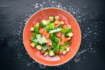Fototapeta na wymiar Salmon Salad and Fresh Vegetables. On a wooden background. Top view. Free space for your text.