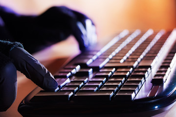 A suspicious person uses the keyboard of a computer
