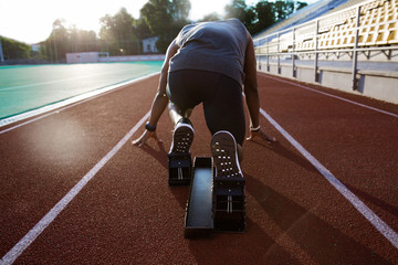 Back view of a young male athlete at starting block