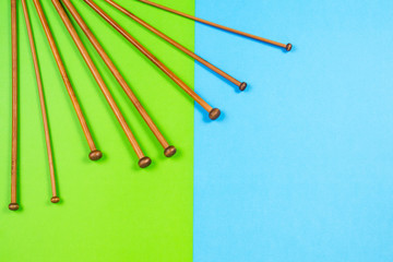 Variety of bamboo knitting needles in different sizes on colorful background