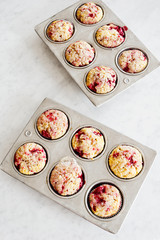 Two Baking Tins Filled With a Dozen Baked Raspberry Muffins or Cupcakes on Kitchen Counter