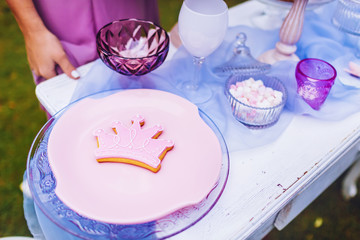 Pink cookies in the shape of a crown on a pink plate. Wedding decoration