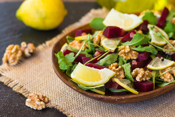 Salad with arugula, beets and nuts In a glass jar in a wooden plate