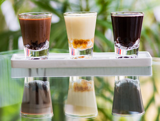 Three kinds of chocolate in shot glasses. - 165727311