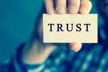 Trust, message on white card man showing, may used for different words and background. Aged toned.