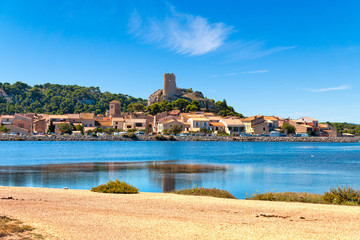Blick auf den Ort Gruissan mit der Burgruine Tour Barberousse und dem Gewässer Etang de Gruissan in Südfrankreich.