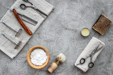 Fototapeta na wymiar Accessories for shaving. Shaving brush, razor, foam, sciccors on grey stone table background top view copyspace