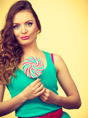 Woman charming girl with lollipop candy