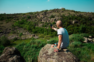 Naklejka premium Tourism concept. Young man taking photo on smartphone while traveling