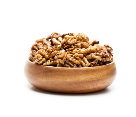 Walnut  kernels in a wooden bowl isolated on white