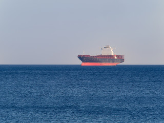 Container  cargo ship anchored off the harbor awaiting  loading
