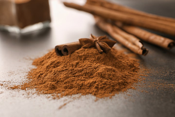 Anise, cinnamon stick and powder on table