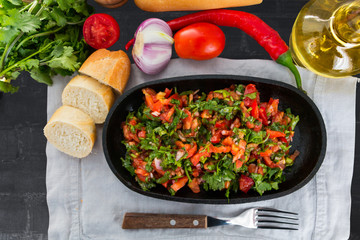 Salsa sauce, olive oil, herbs, vegetables, chili pods, tomatoes on table.  Top view.