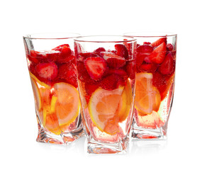 Three glasses of tasty strawberry lemonade on white background