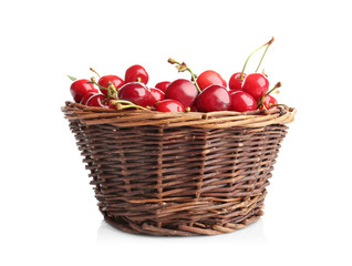 Wicker basket with fresh ripe cherries on white background
