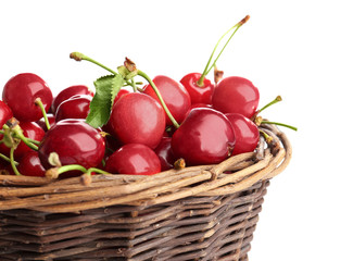 Wicker basket with fresh ripe cherries on white background