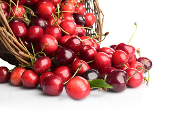 Wicker basket with fresh ripe cherries on white background
