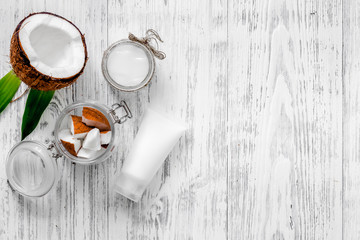 Organic cosmetics with coconut. Coconut cream and oil on wooden background top view copyspace