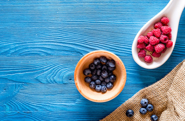 Paspberry and blueberry for preparing jam on blue wooden background top view copyspace