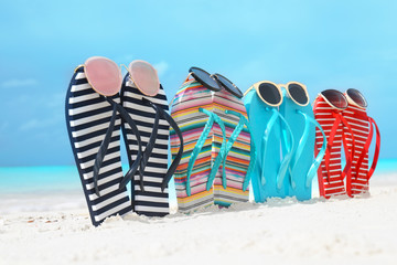 Colorful flip-flops and sunglasses on sea shore. Summer vacation concept