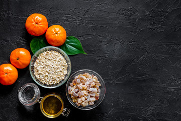 Preparing healthy breakfast. Porridge with oranges and honey on black stone table top view