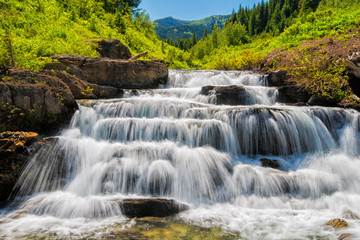 Fototapeta na wymiar A waterfall pours down a mountain valley in Montana