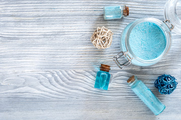 Spa set with sea salt, blue clay and lotion on blue wooden table background top view copyspace